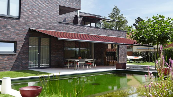 Referenzbild: Kassettenmarkise markilux 6000 an einem Haus mit dunklem Klinker.