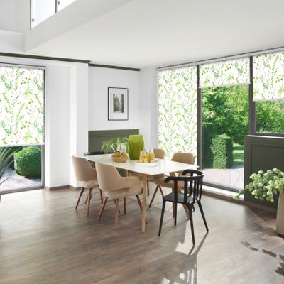 Esszimmer mit vielen Holzelementen, Pflanzen und grün-weiß gemusterten Rollos an den Fenstern