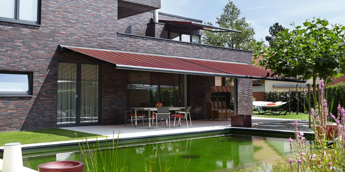 Referenzbild: Kassettenmarkise markilux 6000 an einem Haus mit dunklem Klinker.