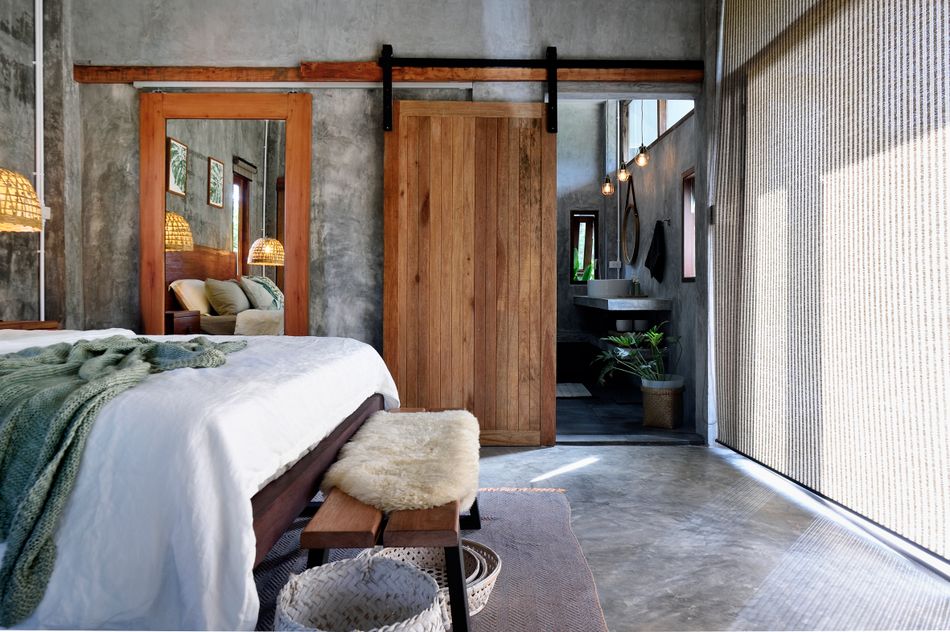 modernes Schlafzimmer mit grauen Wänden und Böden und einer Holzschiebetür und Spiegel mit Holzrahmen