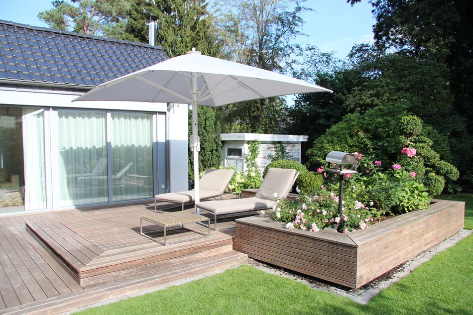 Jumbrella Sonnenschirm beschattet eine Terrasse mit zwei Liegen.