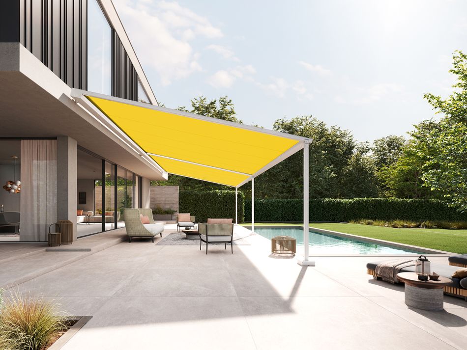 Seitlicher Blick auf ein modernes Kubusgebäude aus Beton und Holzelemente. Eine Pergolamarkise des Typ markilux pergola style mit gelbem Markisentuch überdacht die Terrasse bis zum angrenzenden Pool.