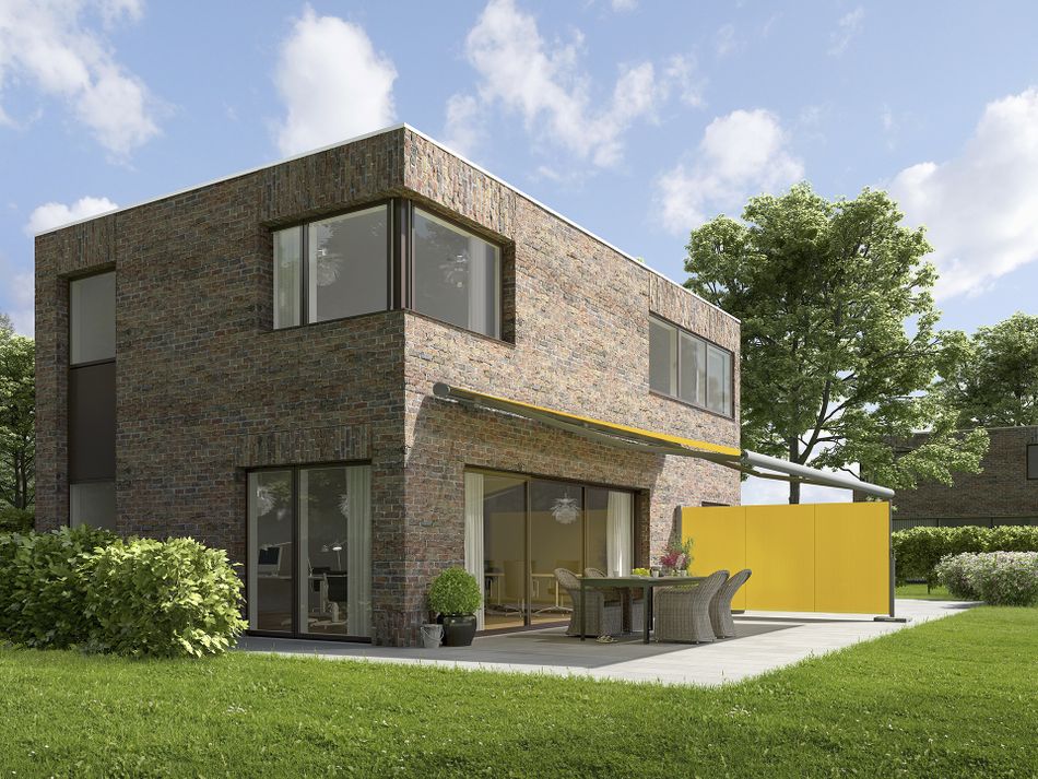 Ausgefahrene Markise mx 790 mit gelbem Tuch und grauem Gestell angebracht an einem modernen Haus.
