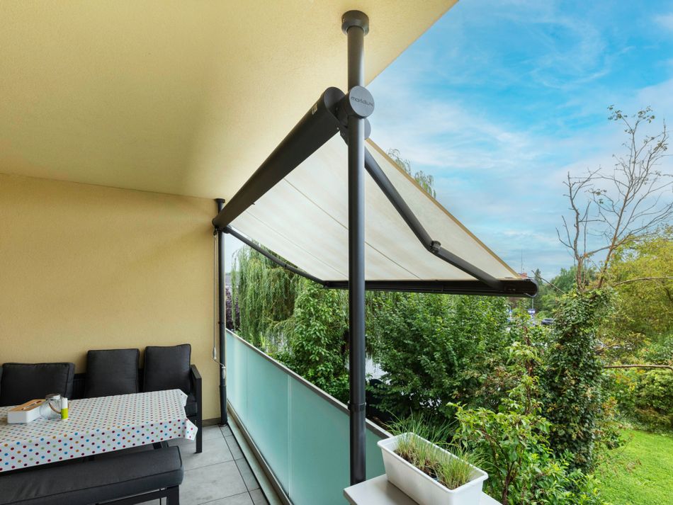 Referenzbild einer gestreiften markilux Klemmmarkise an einem Balkon eines Mehrfamilienhauses.