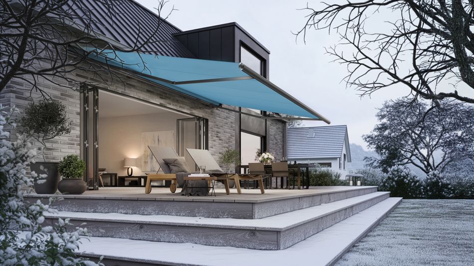 Einfamilienhaus aus Klinker mit Holzterrasse im Winter. An der Fassade hängt eine blaue Markise.