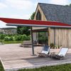 Markisenschirm markilux planet mit rotem Markisentuch vor einem Holzhaus.